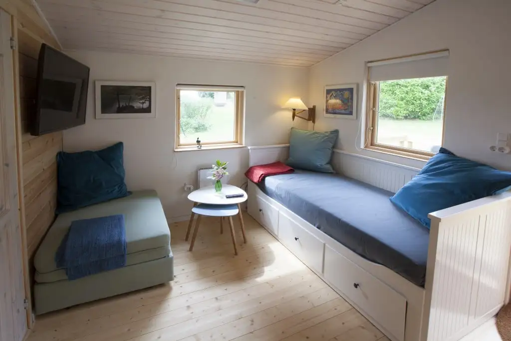 Opholdsrummet i hytten med sovesofa og spiseplads