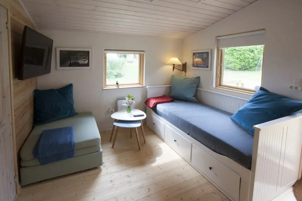 Opholdsrummet i hytten med sovesofa og spiseplads