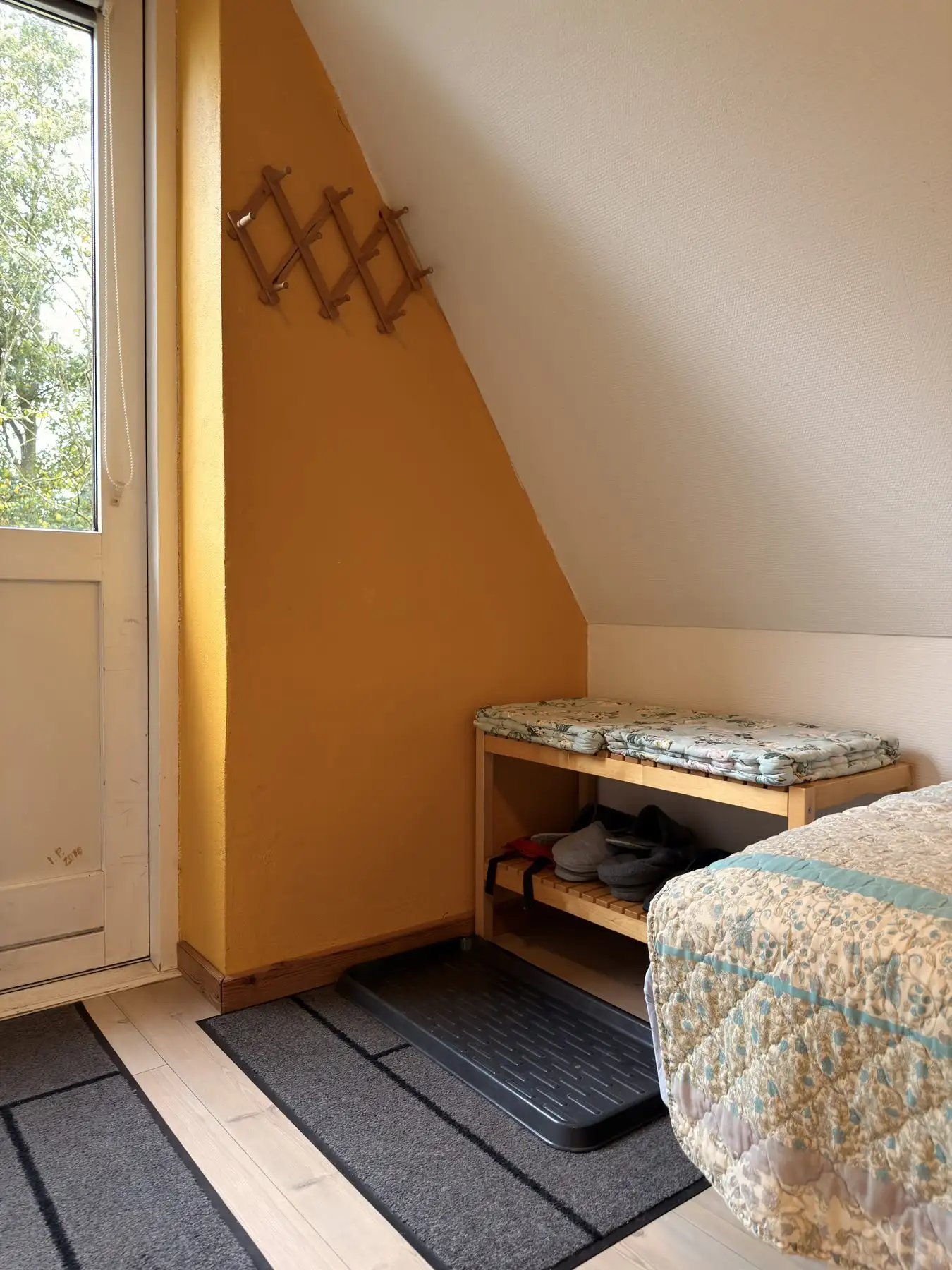 Skobænk og dør ud til det fri i lejlighedens soveværelse