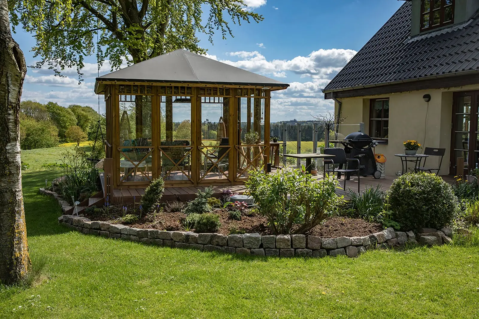 Havehuset med bede foran og landhuset i baggrunden